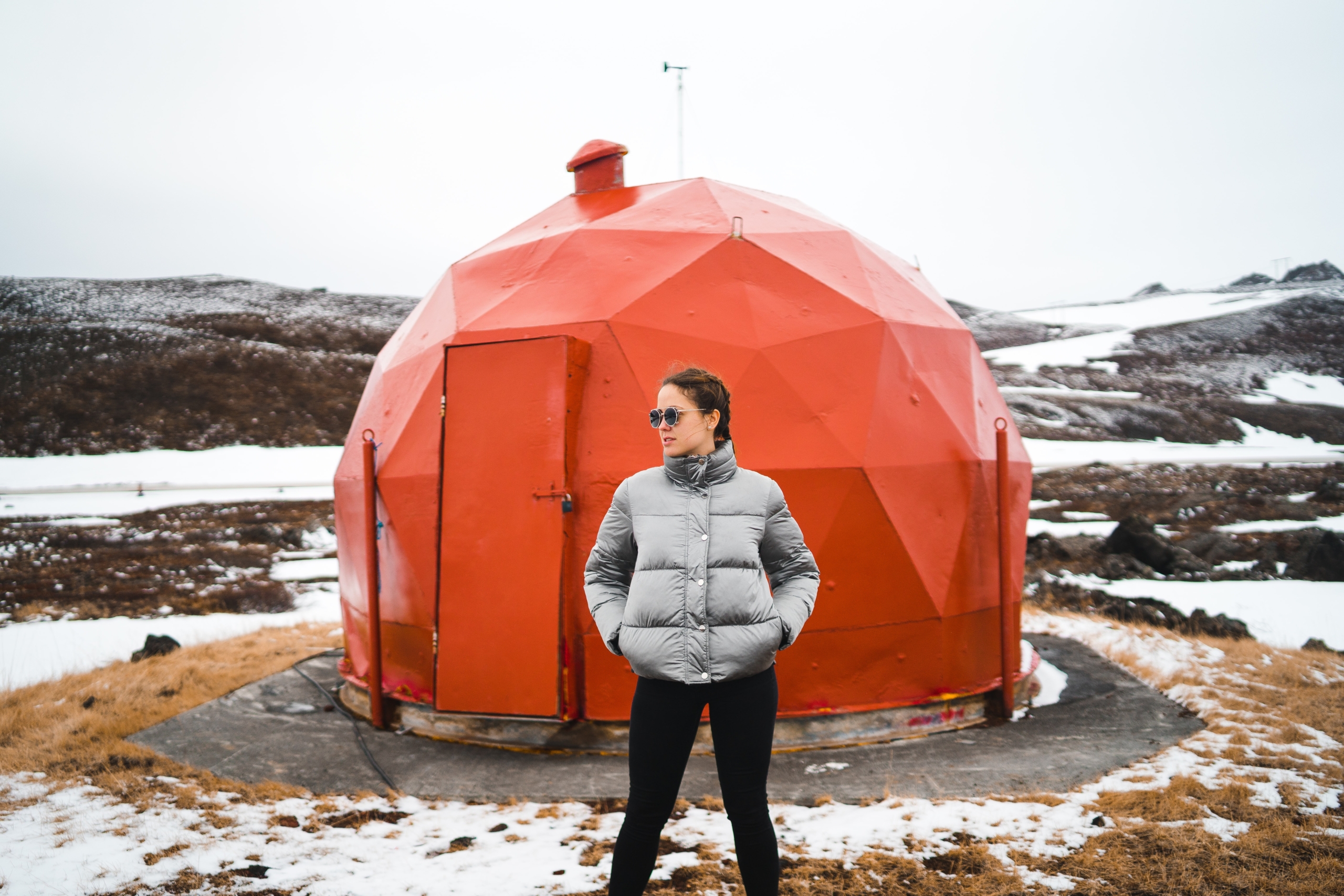 冬キャンプで赤いテントの前に立つ女性