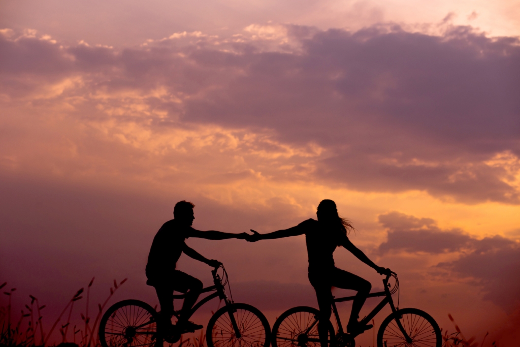 自転車に乗った二人が手をつなぐ影