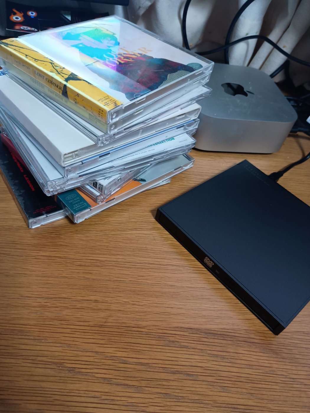 ゲオでレンタルして取り込む前のCDの山。右にロジテックのドライブ、奥にMac mini